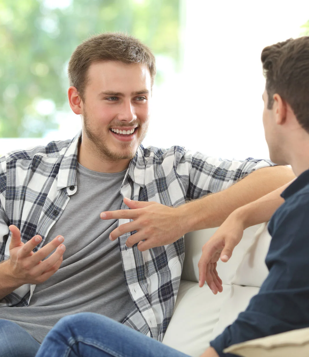 Two men casually talking on a couch