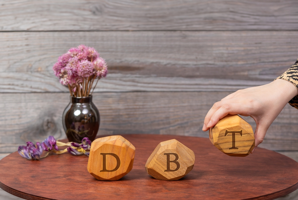 Letters DBT written on wooden blocks. Dialectical Behavior Therapy psychological treatment concept.
