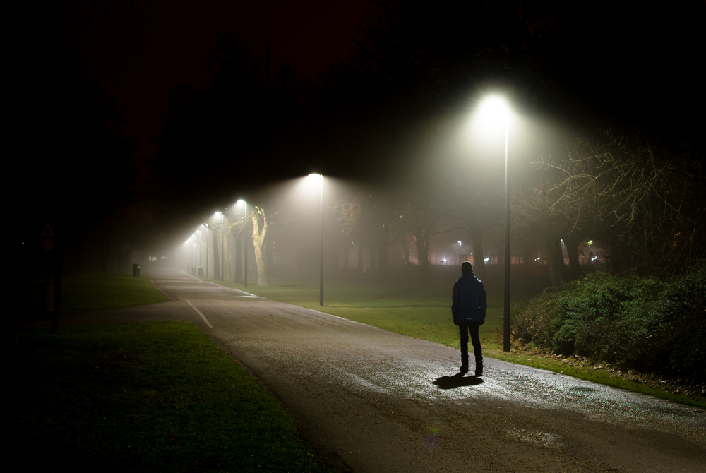 Single Person Walking on Street in the Dark Night